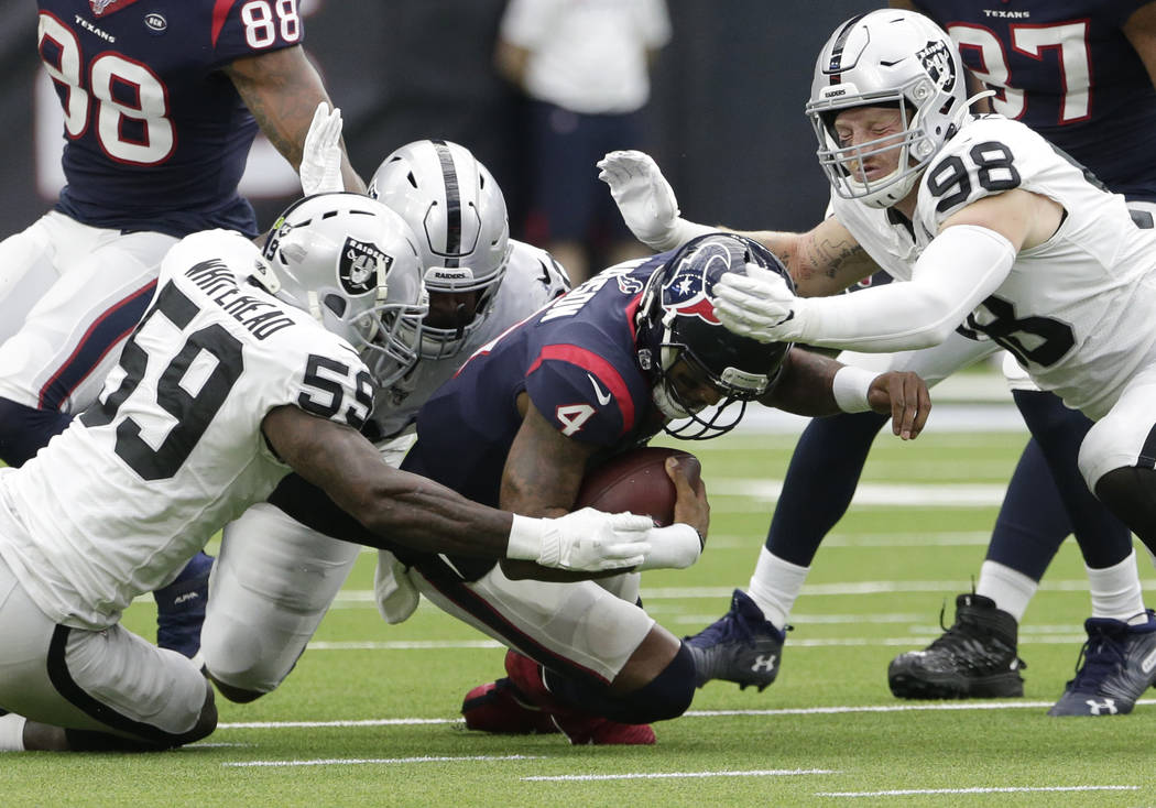 Houston Texans quarterback Deshaun Watson (4) is hit by Oakland Raiders defenders Tahir Whitehe ...