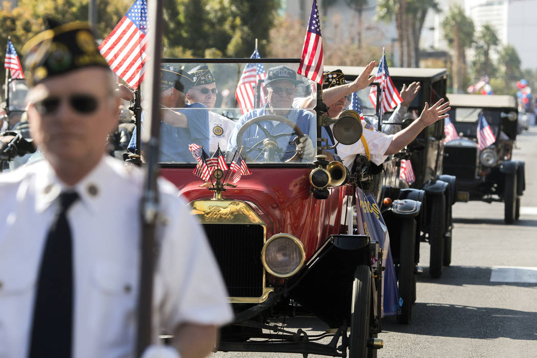 Members of American Legion Post 76 wave to the crowd on 4th Street during the 2016 Veterans Day ...