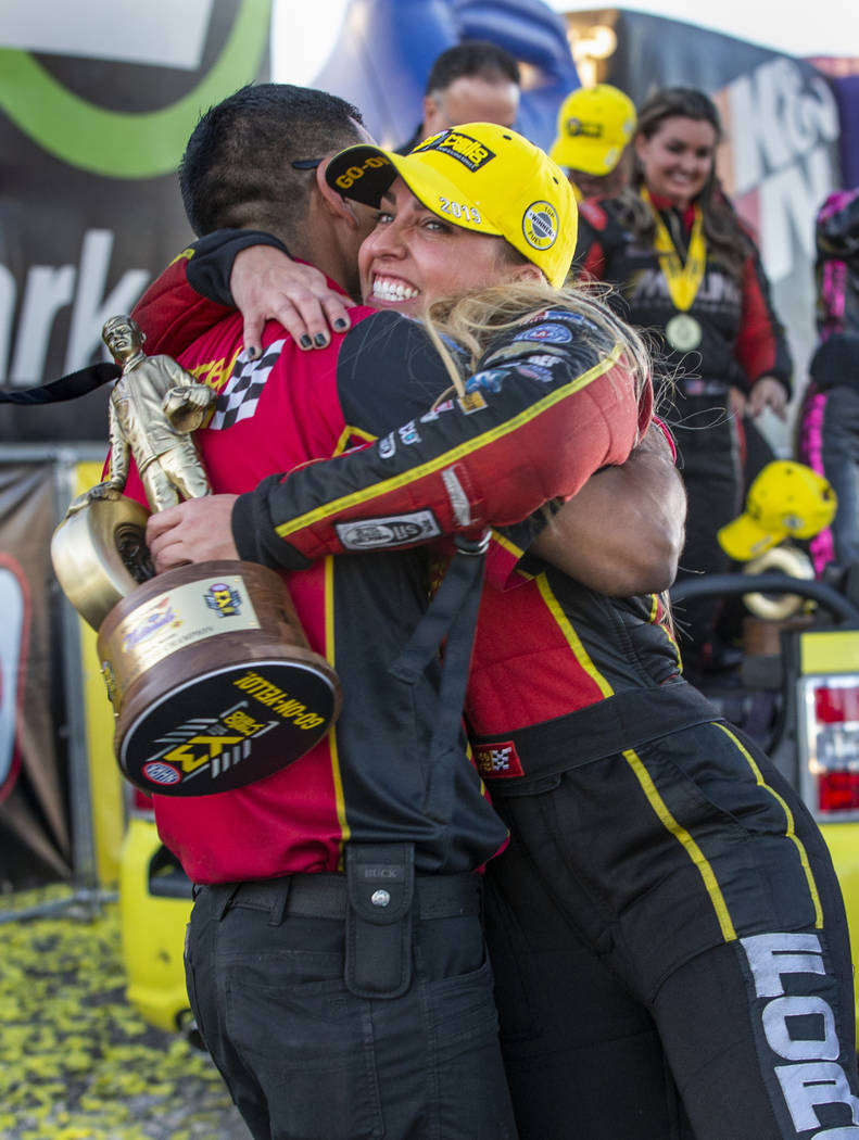 Top Fuel race winner Brittany Force, left, hugs crew member Narciso Bravo while carrying her tr ...