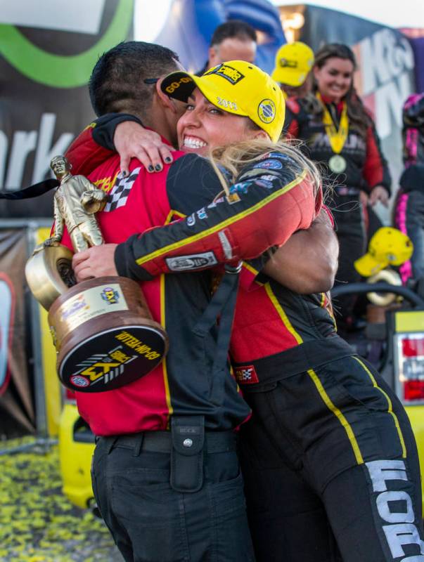 Top Fuel race winner Brittany Force, left, hugs crew member Narciso Bravo while carrying her tr ...