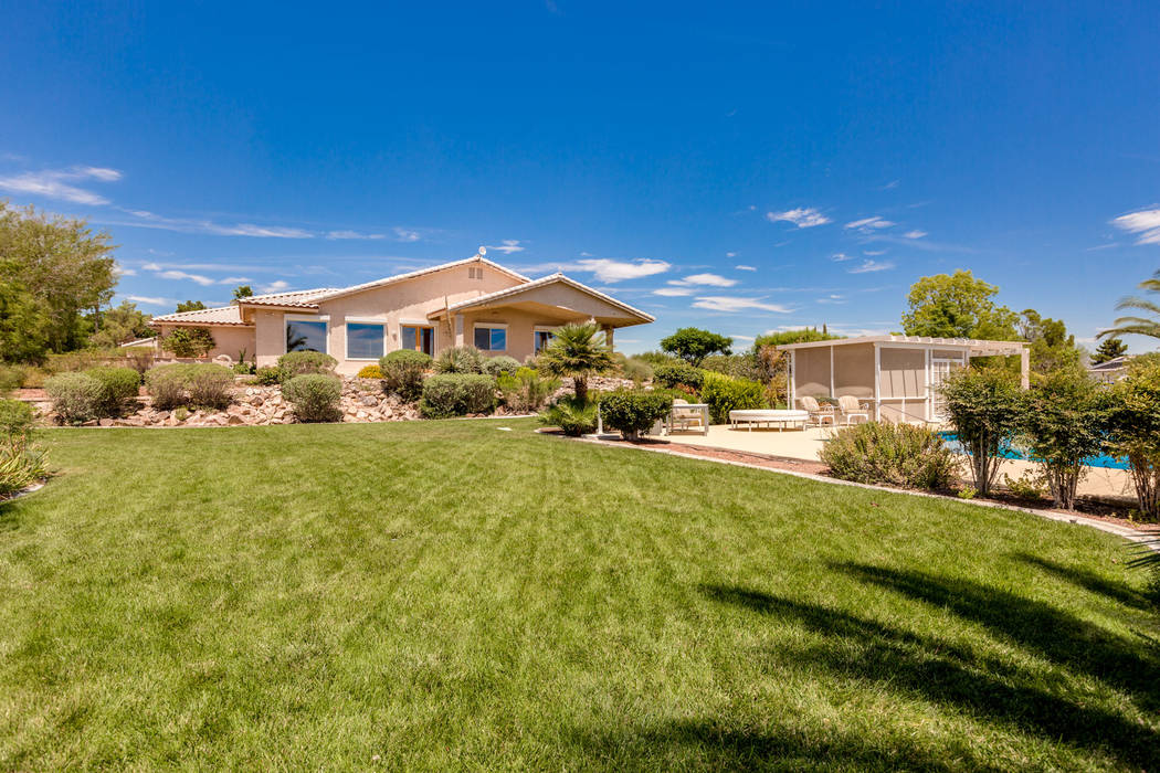 The spalike backyard showcases a 20,000-gallon salt-converted pool with motorized cover. (Luxur ...