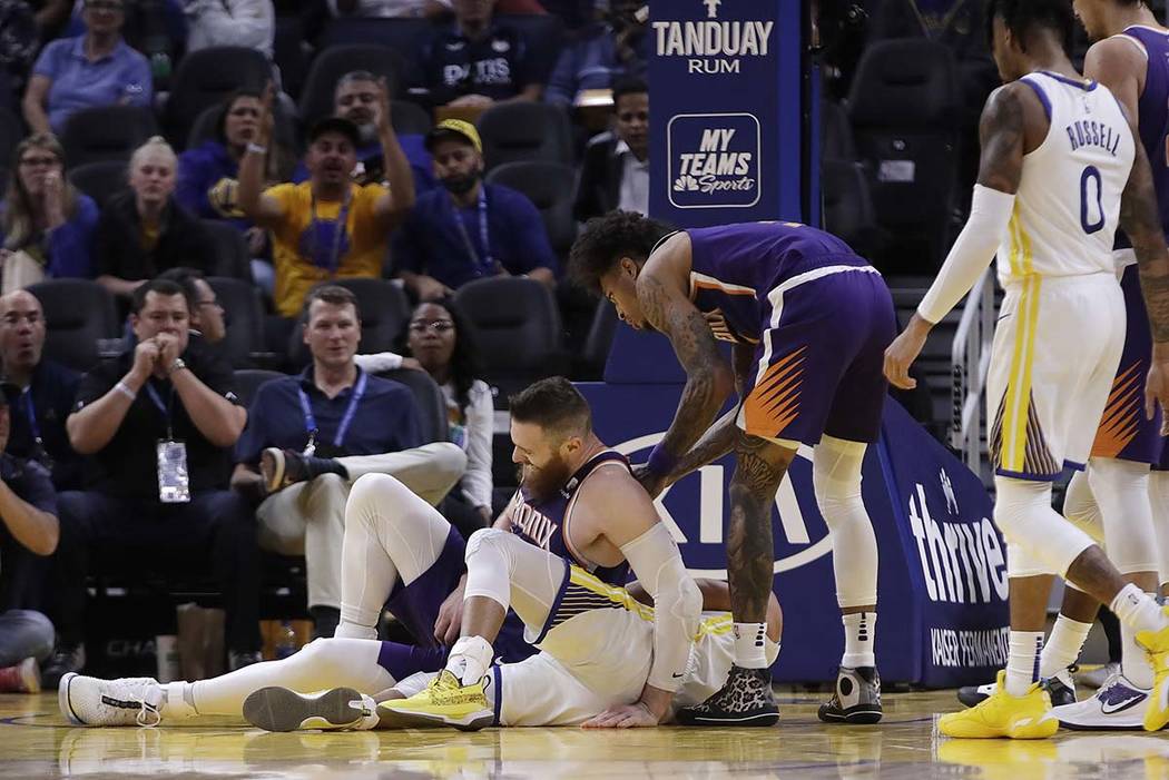 Phoenix Suns' Aron Baynes, left, gets up after falling onto Golden State Warriors' Stephen Curr ...