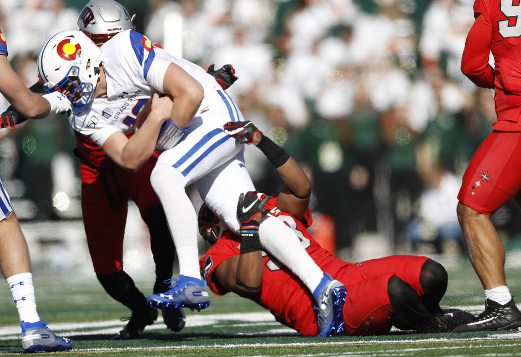Colorado State quarterback Patrick O'Brien, left, is dragged down after a short gain by UNLV de ...