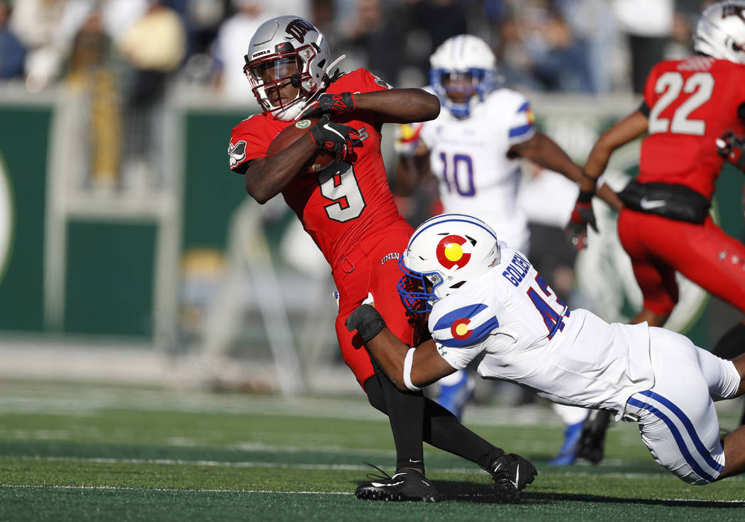 UNLV wide receiver Tyleek Collins, left, is dragged down by Colorado State linebacker Troy Gold ...