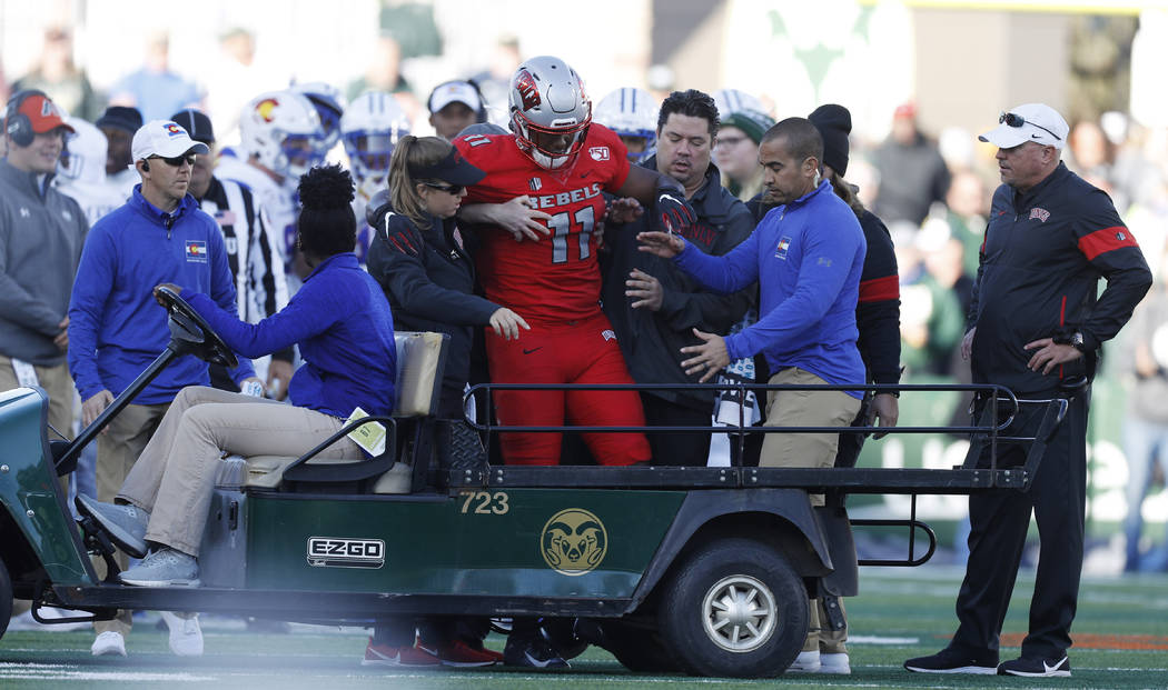 UNLV tight end Noah Bean, center, is helped onto a cart after being injured against Colorado St ...