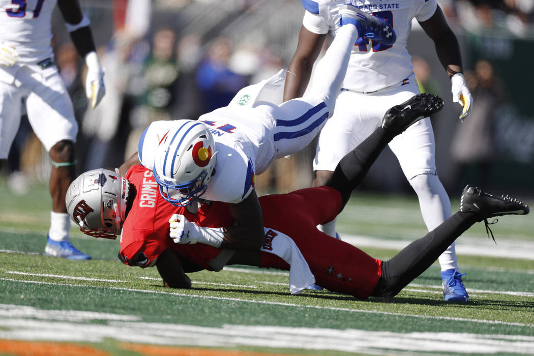 UNLV wide receiver Randal Grimes, bottom, is tackled after catching a pass for a first down by ...