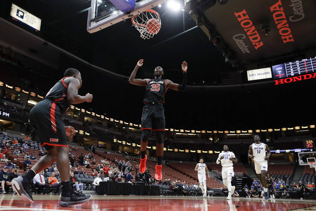 Cal State Northridge forward Lamine Diane celebrates a basket by guard Terrell Gomez, left, aga ...