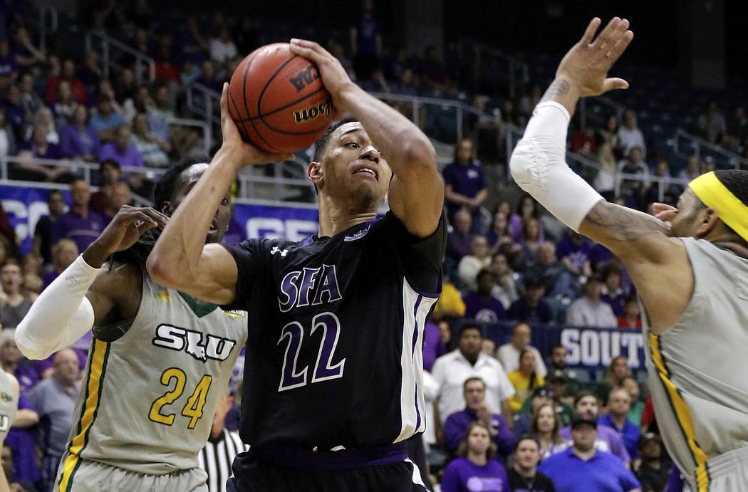 Stephen F. Austin forward TJ Holyfield (22) looks for a way between Southeastern Louisiana guar ...