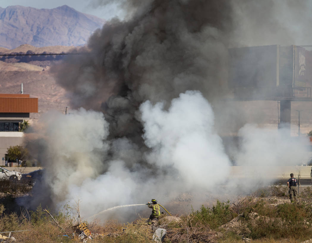 The Henderson Fire Department works a small brush fire just off of the southbound lanes of Inte ...