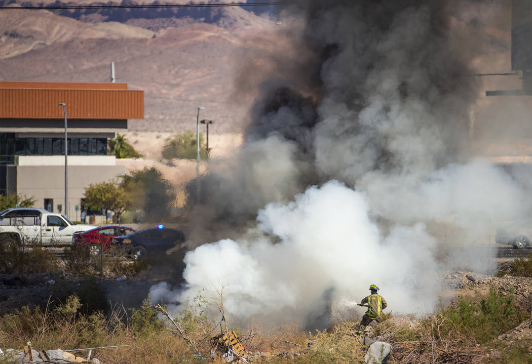 The Henderson Fire Department works a small brush fire just off of the southbound lanes of Inte ...