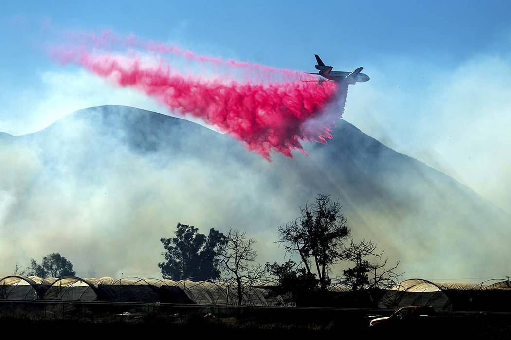 An air tanker drops retardant as the Maria Fire approaches Santa Paula, Calif., on Friday, Nov. ...