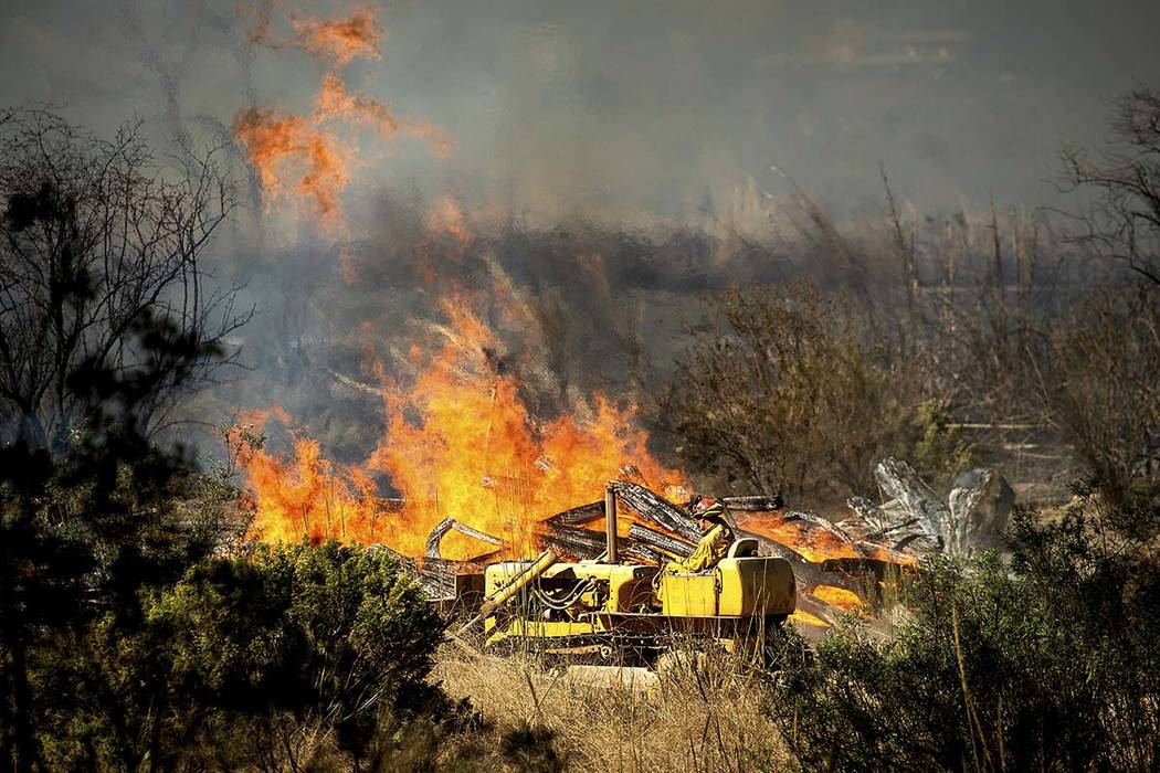 A firefighter creates a fire break as the Maria Fire approaches in Santa Paula, Calif., on Frid ...