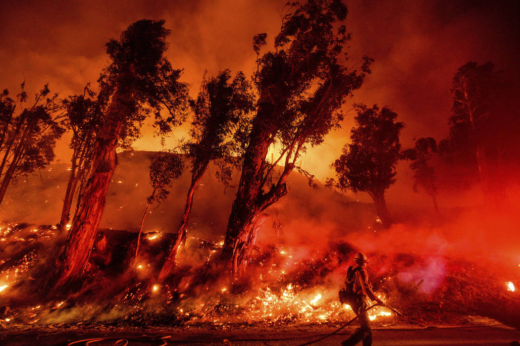 FILE - In this Nov. 1, 2019 file photo flames from a backfire consume a hillside as firefighter ...