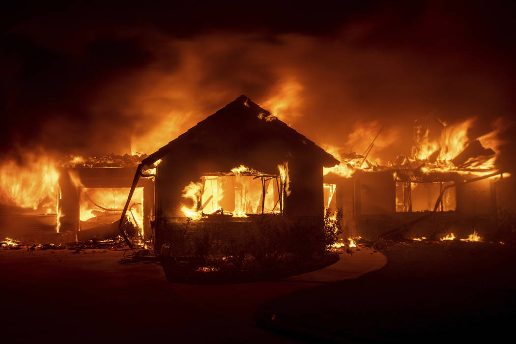 FILE - In this Oct. 31, 2019 file photo flames from the Hillside Fire consume a home in San Ber ...