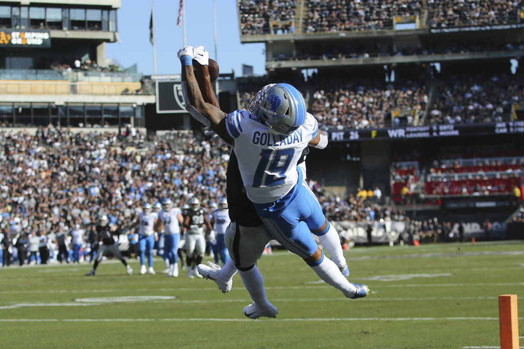 Oakland Raiders cornerback Daryl Worley, obscured, intercepts a pass intended for Detroit Lions ...