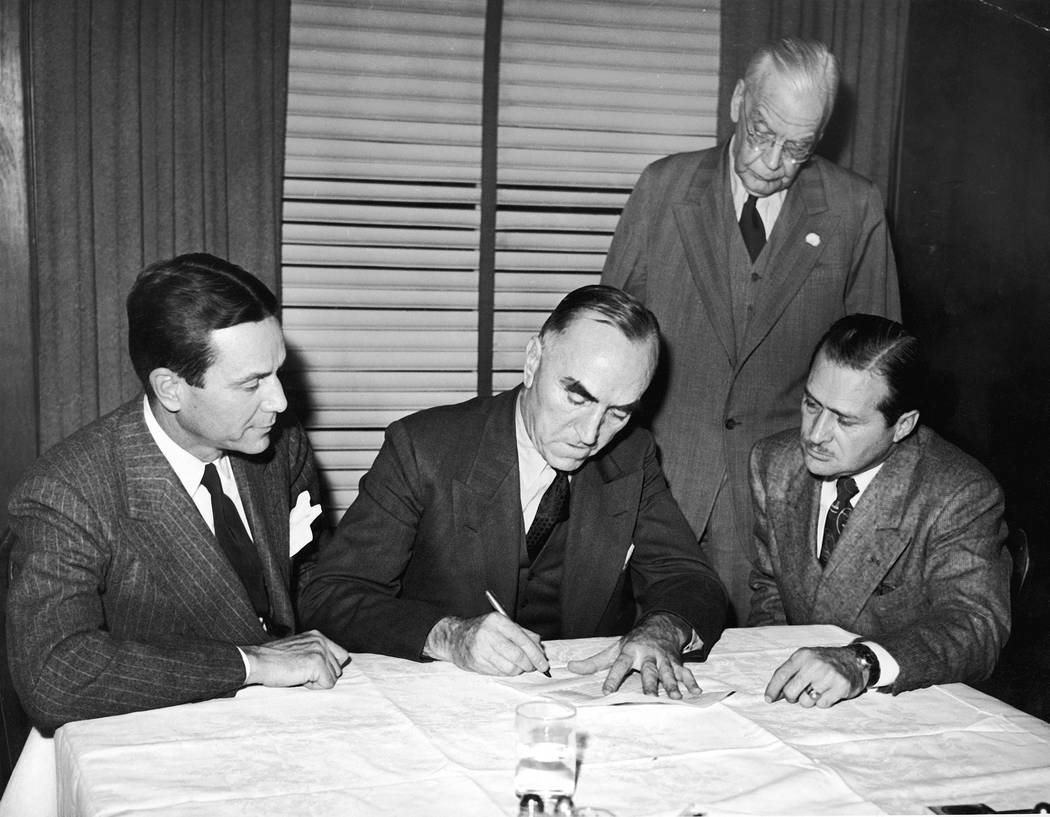FILE - In this Nov. 14, 1945, file photo, Eddie Rickenbacker, center, signs papers selling the ...
