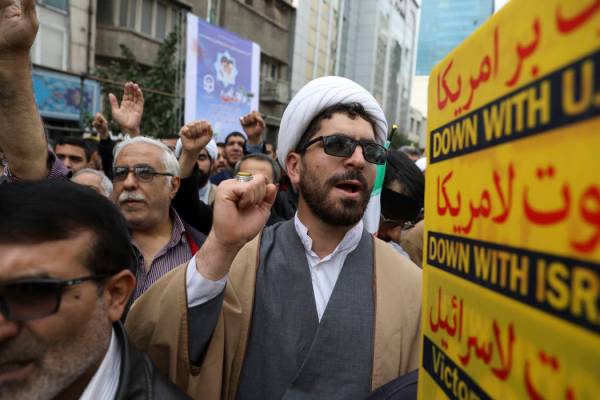 A Shiite Muslim cleric chants slogan during an anti-U.S. annual rally in front of the former U. ...