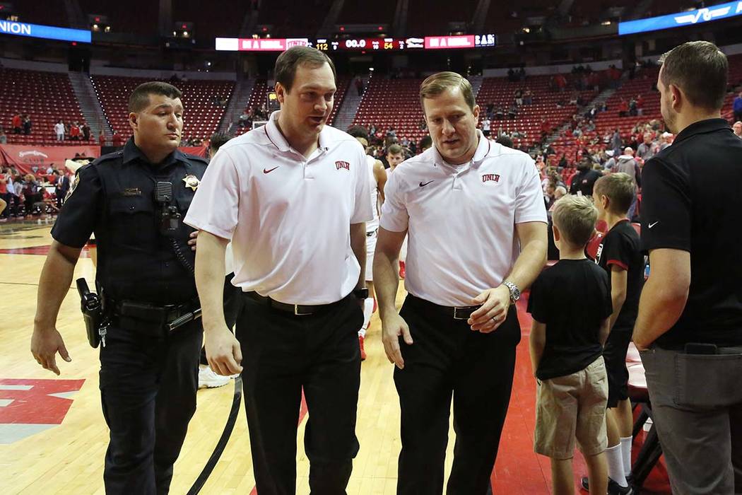 UNLV's basketball head coach T.J. Otzelberger, right, and assistant coach Kevin Kruger leave th ...