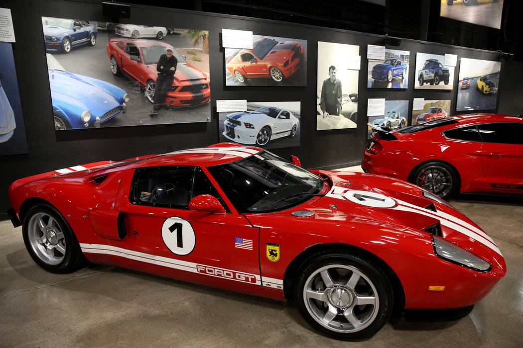 Photos of late car racing and car making legend Carroll Shelby above a 2004 Ford GT prototype, ...