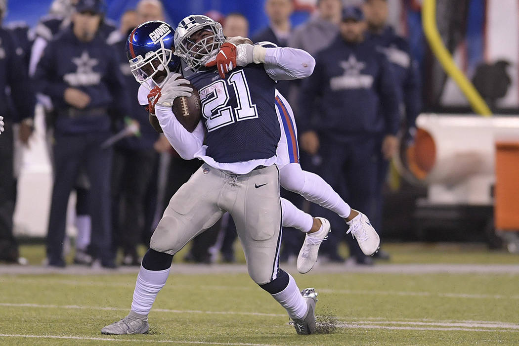 Dallas Cowboys running back Ezekiel Elliott (21) is tackled by New York Giants free safety Anto ...