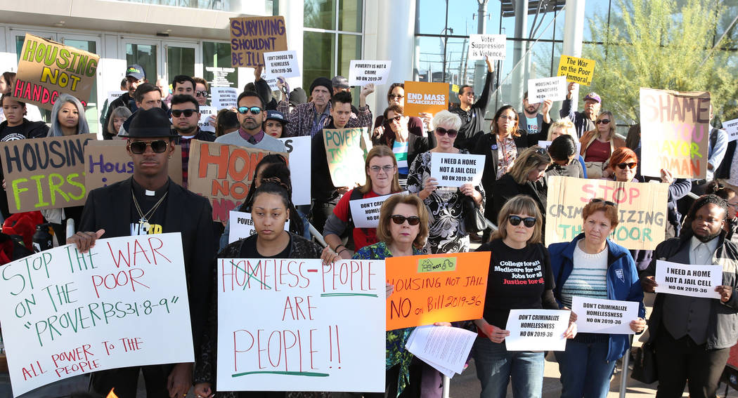 Protesters hold signs outside Las Vegas City Hall during a protest against the city council's c ...