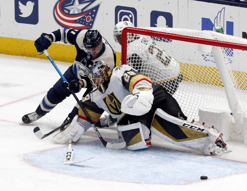 Vegas Golden Knights goalie Marc-Andre Fleury, right, stops a shot by Columbus Blue Jackets for ...