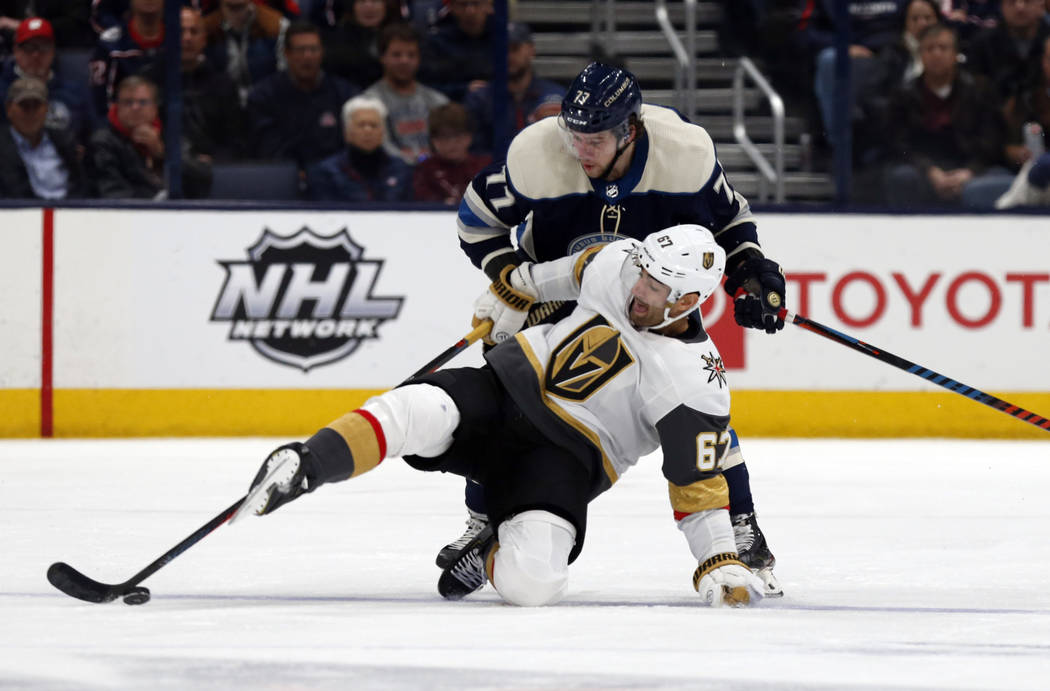 Vegas Golden Knights forward Max Pacioretty falls in front of Columbus Blue Jackets forward Jos ...