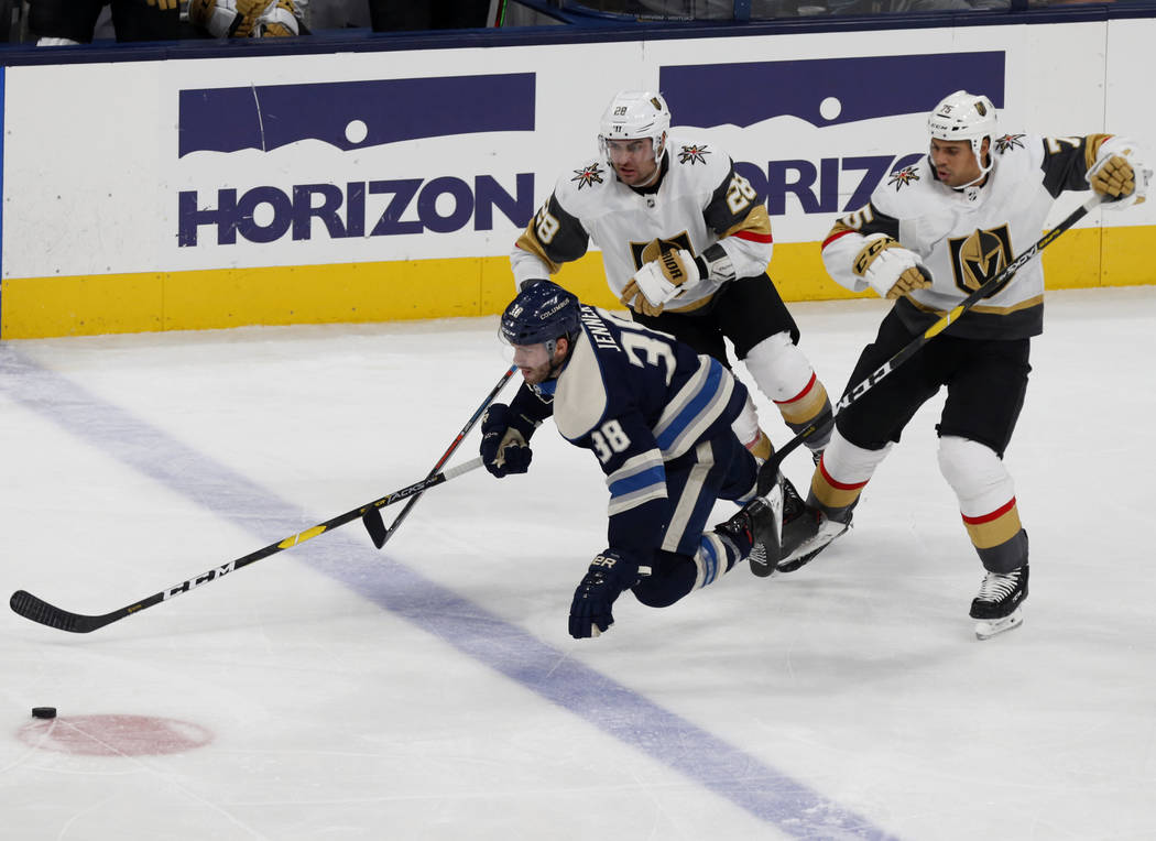 Columbus Blue Jackets forward Boone Jenner, left, falls in front of Vegas Golden Knights forwar ...