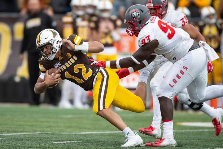 Wyoming quarterback Sean Chambers runs for yardage as New Mexico defenseman Nahje Flowers pursu ...