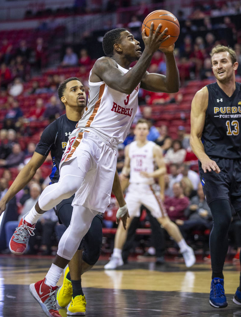 UNLV Rebels guard Amauri Hardy (3) looks to shoot past Purdue Fort Wayne forward Matt Holba (13 ...