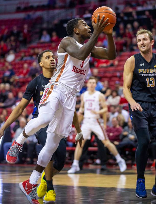 UNLV Rebels guard Amauri Hardy (3) looks to shoot past Purdue Fort Wayne forward Matt Holba (13 ...