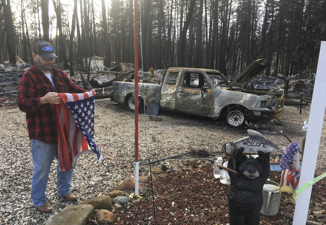 FILE - In this Dec. 5, 2018, file photo, Jerry McLean folds the flag that was flying outside th ...