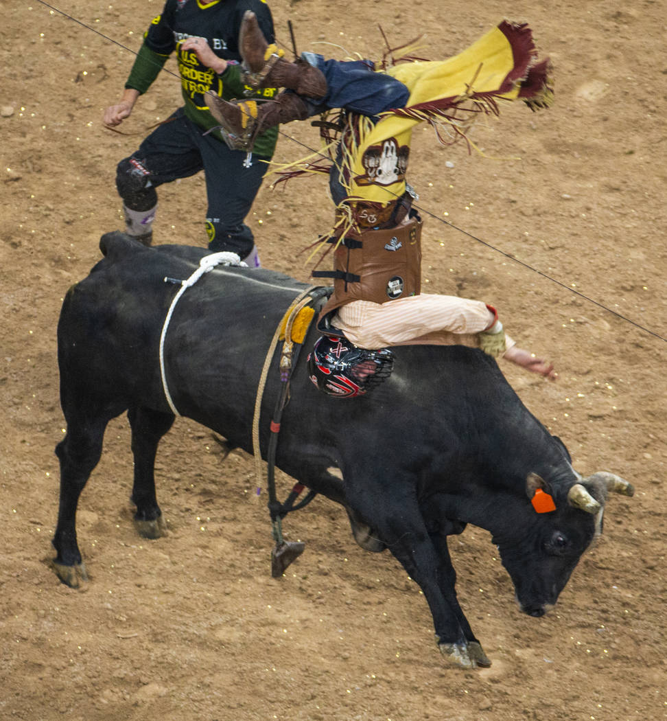 Daniel Tinsman flips over I'm Legit Too after getting the horns during the PBR Finals at T-Mobi ...