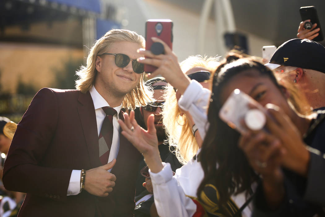Golden Knights' William Karlsson takes pictures with fans on the gold carpet after arriving for ...