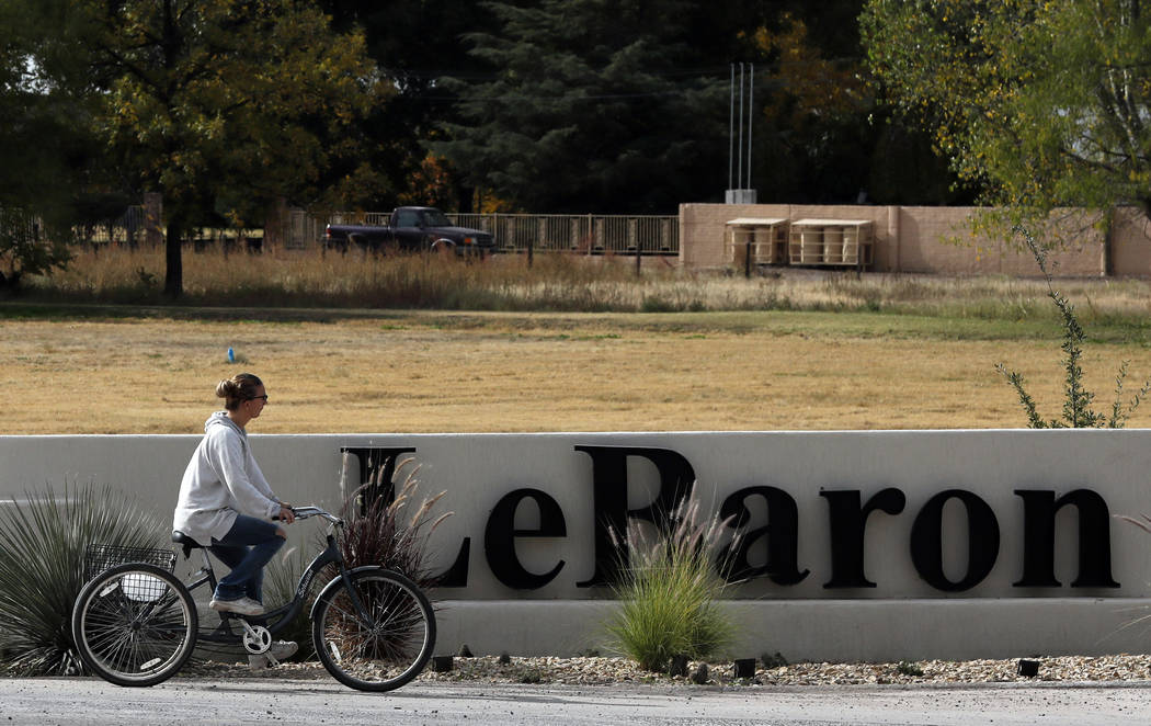 A woman cycles past a sign announcing the Colonia LeBaron, a community settled by members of th ...