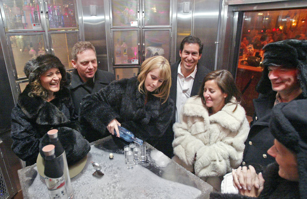 Vodka host Kelly Reid, center, pours shots of ZYR vodka to a fur-clad group from Atlanta, Ga., ...