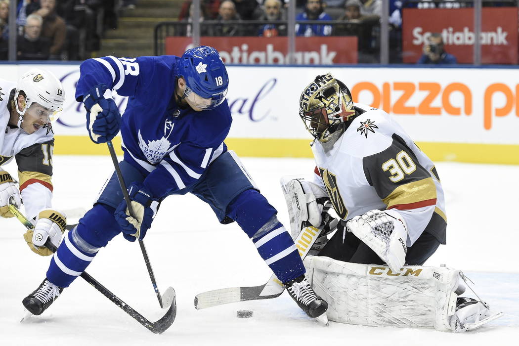 Toronto Maple Leafs center Mitchell Marner, back, watches as a goal by center John Tavares, goe ...