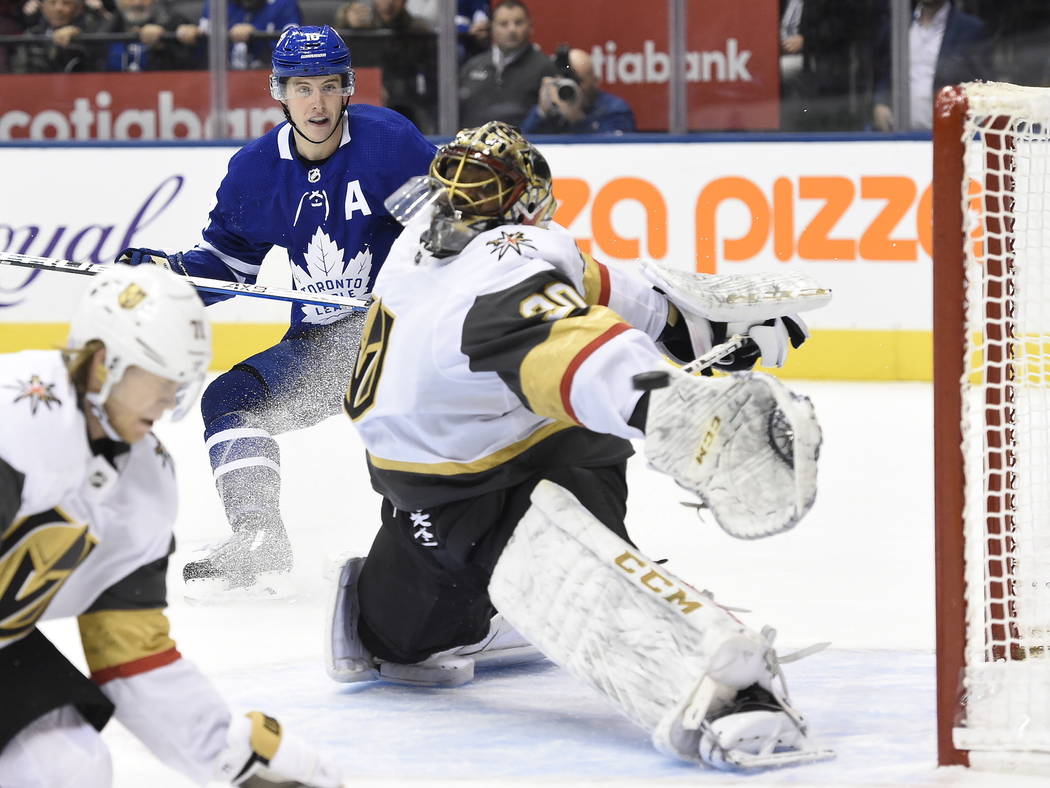 Toronto Maple Leafs center Mitchell Marner, back, watches as a goal by center John Tavares, goe ...