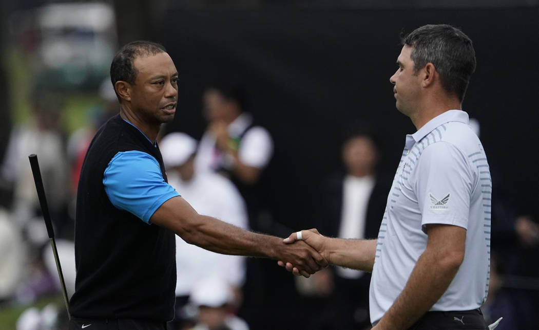 Tiger Woods of the United States, shakes hands with Gary Woodland of the United States on the18 ...