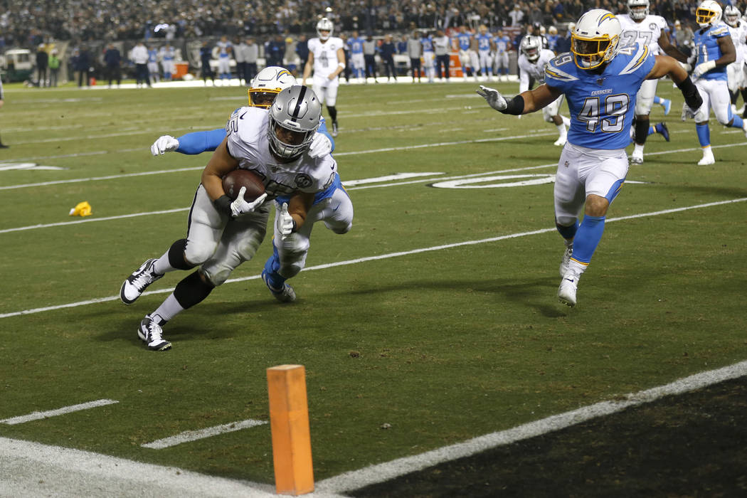 Oakland Raiders running back Alec Ingold (45) runs toward the end zone to score past Los Angele ...