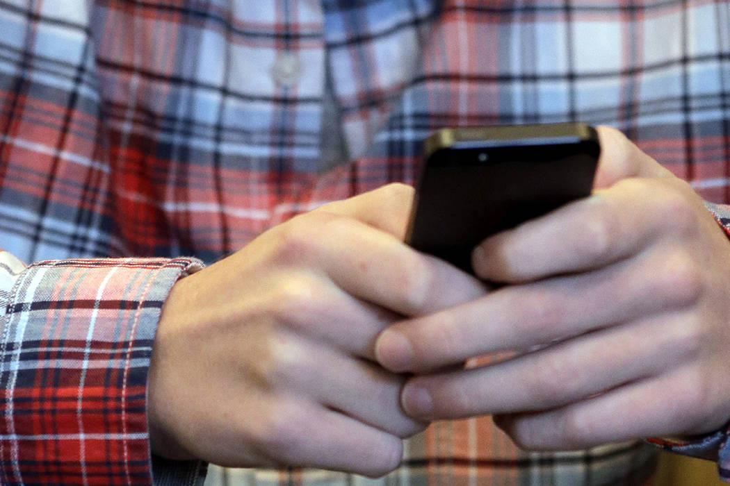 FILE - In this Oct. 24, 2013, file photo, a person checks their smartphone in Glenview, Ill. A ...