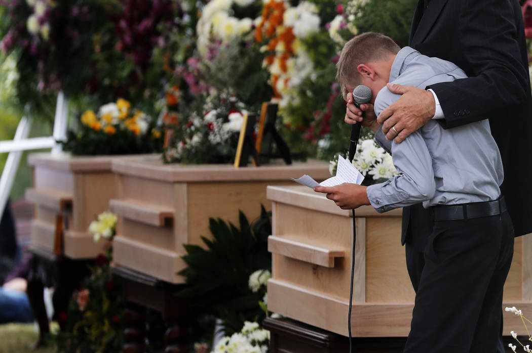 A boy pauses as he speaks next to the coffins of Dawna Ray Langford, 43, and her sons Trevor, 1 ...