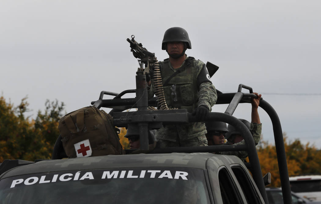 Mexican soldiers stand guard as Dawna Ray Langford, 43, and her sons Trevor, 11, and Rogan, 2, ...