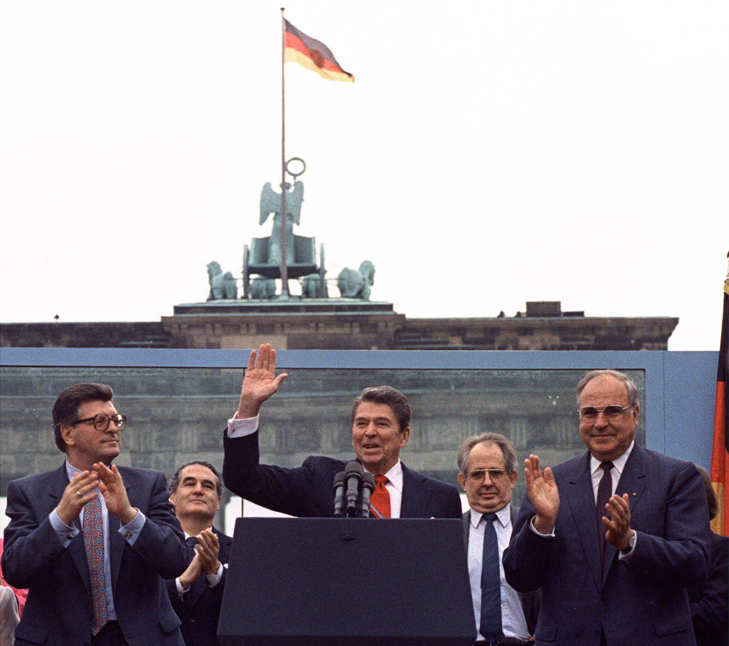 FILE - In this on Friday, June 12, 1987 file photo, U.S. President Ronald Reagan acknowledges t ...