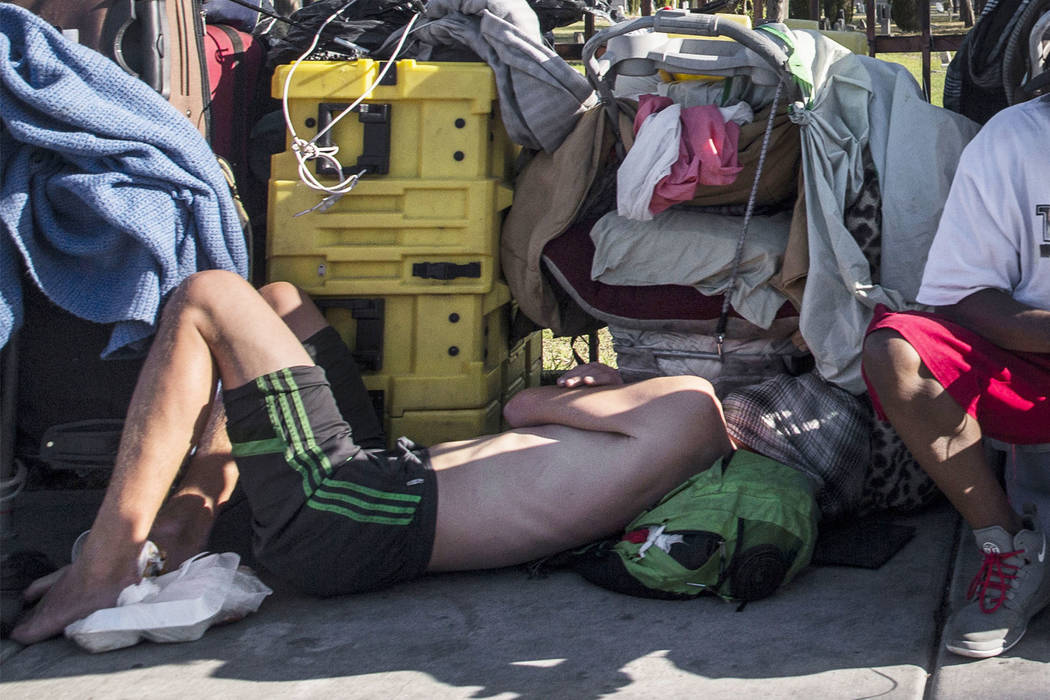 In this May 3, 2018, file photo, a man sleeps on the ground on East Owens Avenue in Las Vegas. ...