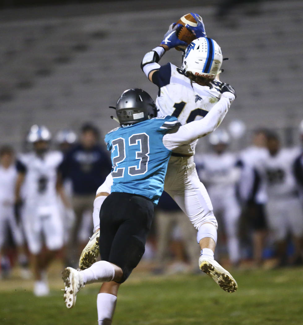 Foothill's Thomas Fisher-Welch (18) catches a pass under pressure from Silverado's Breven Palpa ...