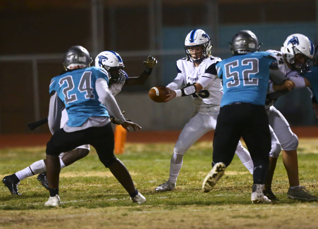 Foothill quarterback Koy Riggin (15) hands the ball off to Foothill's Kendric Thomas (2) during ...