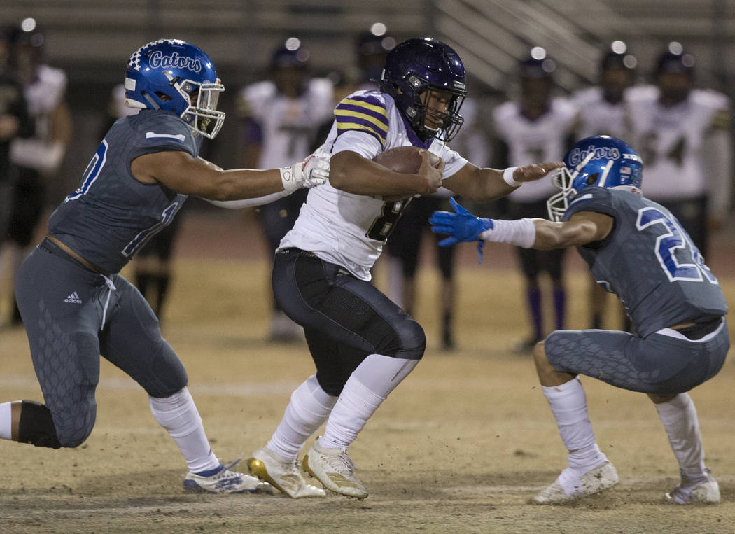 Durango's Ryan Cabase (8) splits Green Valley defenders Christopher Lyons (10) and Anton Mazzul ...