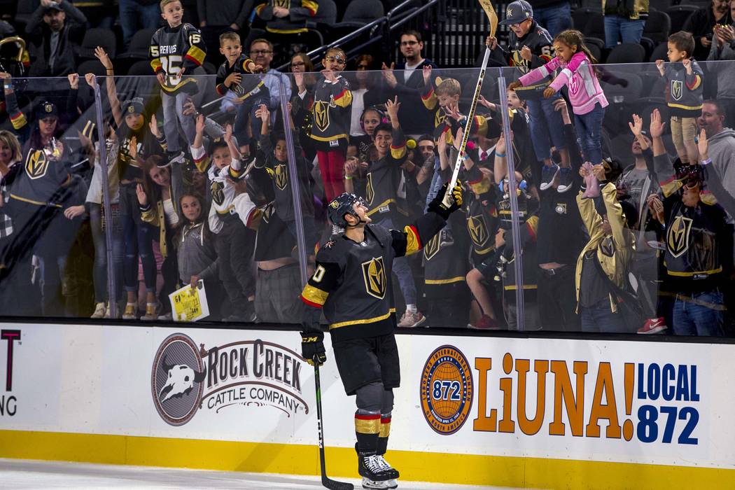 Vegas Golden Knights center Nicolas Roy (10) gives away his stick to a lucky fan after scoring ...