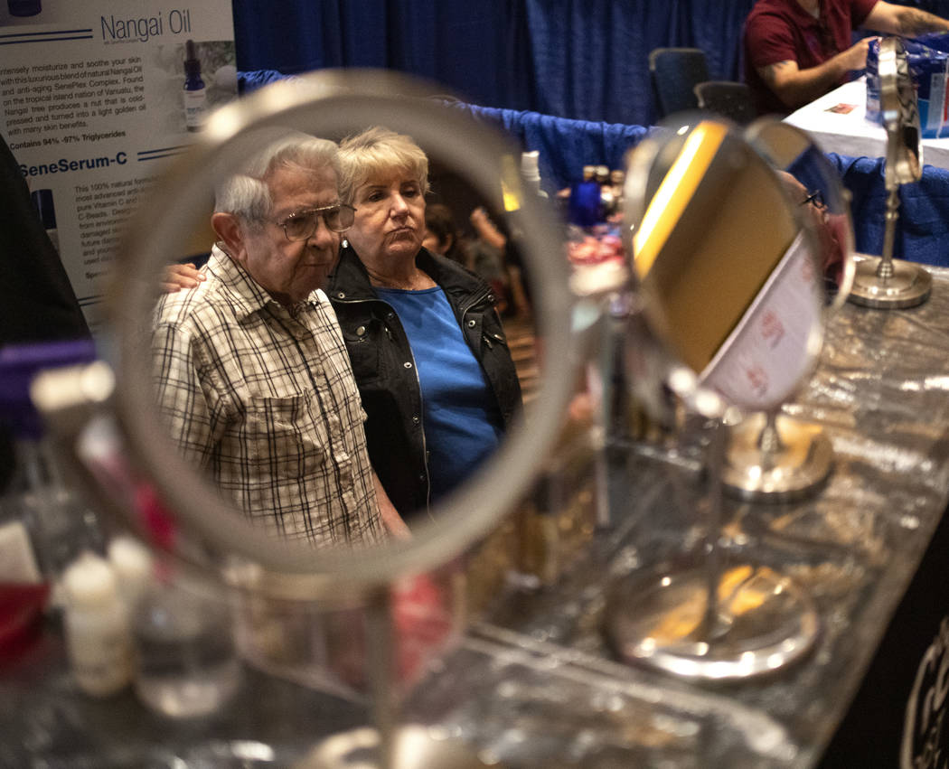 Marvin Labowitz, left, and Elna Fischer, right, are reflected in a mirrors during the AgeWell E ...